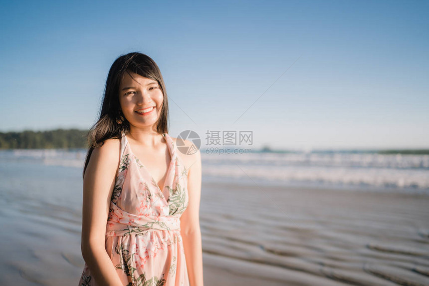 年轻的亚洲女人在海滩上感到快乐图片
