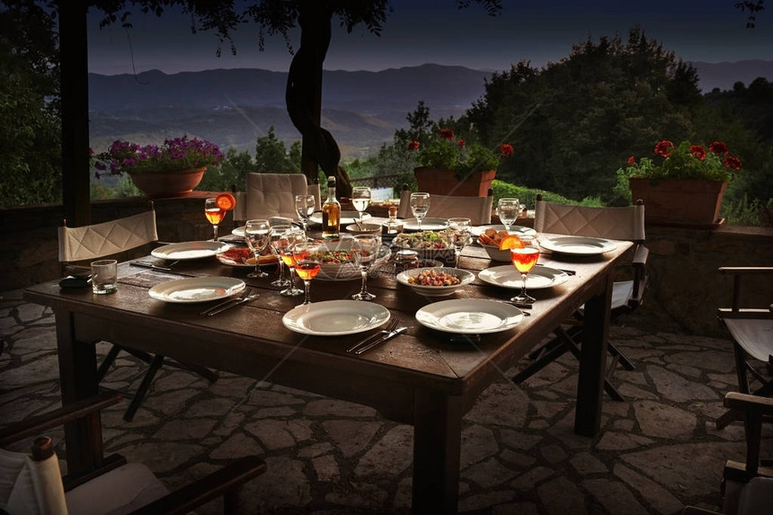为晚上宴准备的花园梯田上的大型生菜桌图片