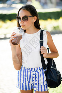 一个可爱漂亮的少女在夏日炎热中喝杯凉爽的饮图片