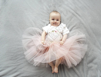 穿着礼裙的可爱滑稽女婴在床图片