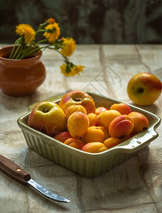 橄榄色陶瓷方盘中的成熟油桃和杏子图片