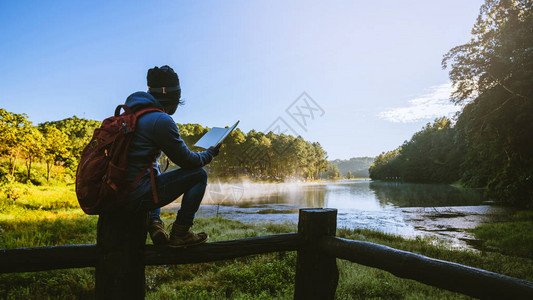 一个年轻人正坐着读一本关于木材的书图片