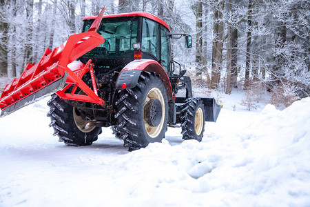大拖拉机在冬天从雪中清理道路季节工作图片
