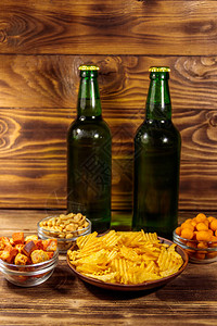 木桌上的啤酒瓶和各种啤酒小吃图片
