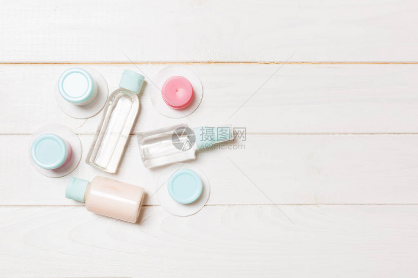在白色木制背景上旅行的小瓶组为您的想法复制空间化妆品的平躺组合物带化妆棉的奶油图片