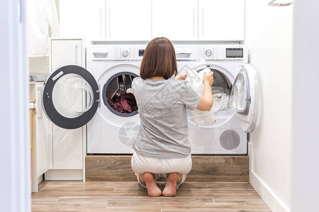 将妇女装上洗衣机的脏衣服用于图片