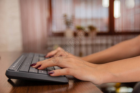 女人在家里用电脑键盘写博客图片