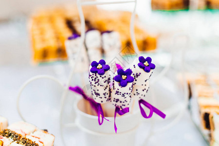 婚礼糖果棒上有紫色花朵的美丽甜点特写图片