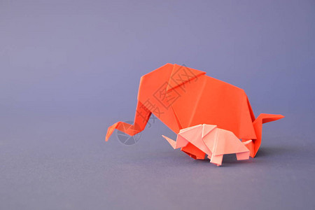 一头大小折纸大象用红色和粉红色的纸折叠起来图片