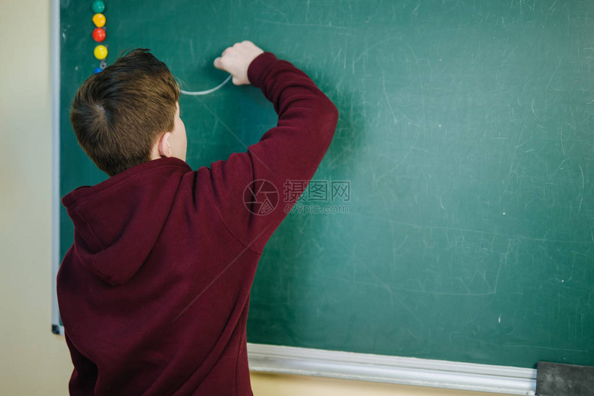 英俊的大学生在黑板黑板前的数学课上图片