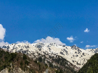 美丽的雪山风景与蓝色天空和云彩在日本地高山的田山村图片