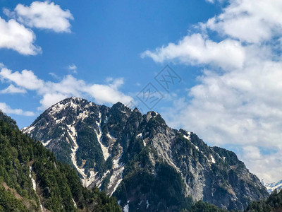 美丽的雪山风景与蓝色天空和云彩在日本地高山的田山村图片