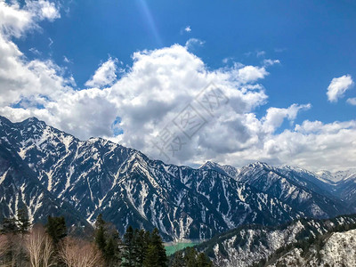 美丽的雪山风景与蓝色天空和云彩在日本地高山的田山村图片