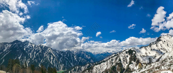 立山黑部高山路线上蓝天白云的美丽雪山景色图片