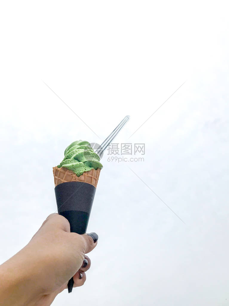 手握着绿色茶叶和冰淇淋图片