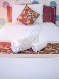 靠近窗户的白色干净床上的白色干净毛巾图片