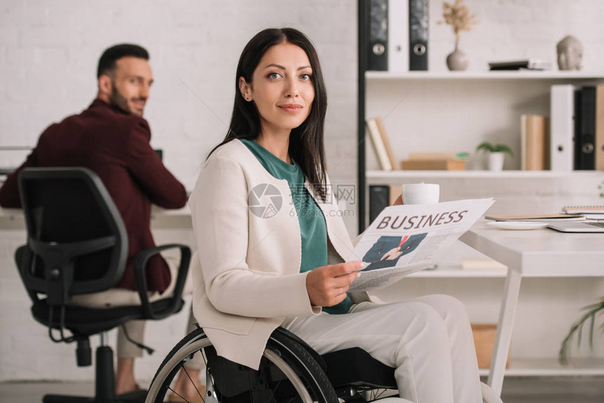 选择积极的残疾女商人坐在办公室英俊的同事旁边图片