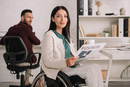 选择积极的残疾女商人坐在办公室英俊的同事旁边图片