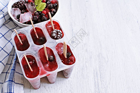 自制的野生浆果冰棒配浆果和薄荷叶清爽图片