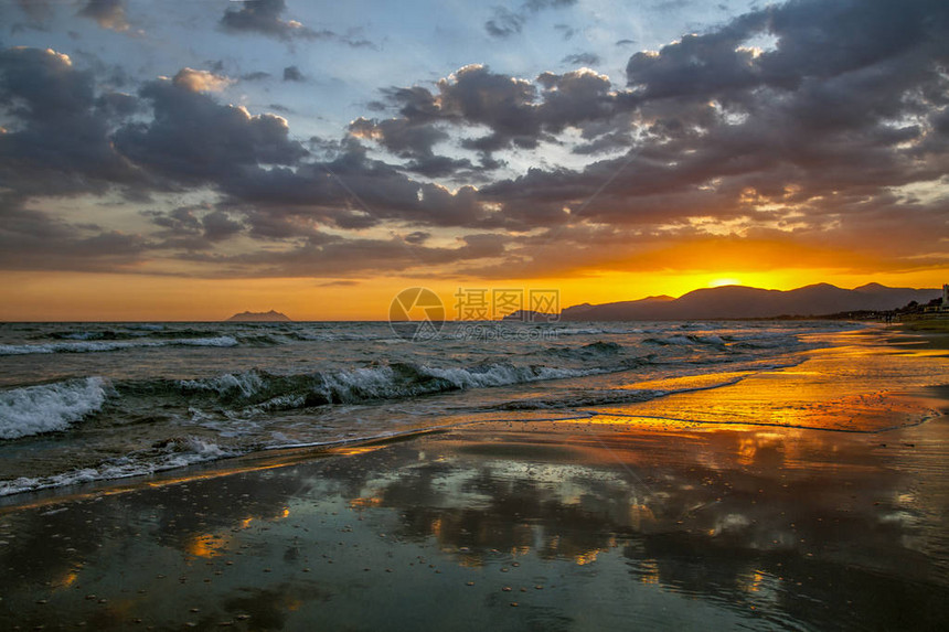 在日落背景的日落时在沙滩上的惊人景观亚得里亚海沿岸意大利的假图片