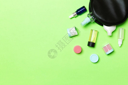绿色背景的化妆品袋中掉出的一组美容奶油瓶您的设计空间皮肤护理概念图片