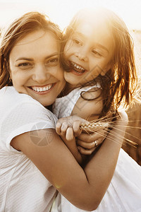 一个拥抱女儿的可爱母亲的肖像图片