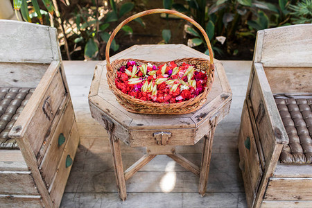 木制餐桌上带红花和白花的木制篮子图片