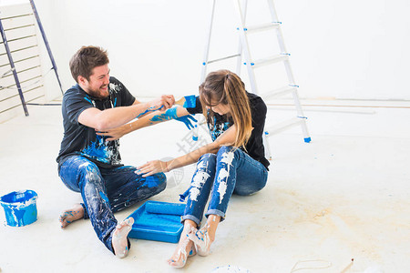装修重新装修和室内设计概念年轻夫妇坐在白色地板上倒油图片