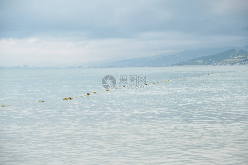 在恶劣天气下山区和城市背景的黑海水面上渔网捕鱼图片