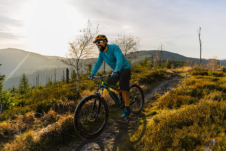 骑自行车的骑手在日落山区景观上骑车图片