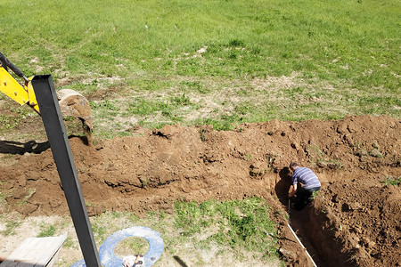 开沟挖土机在私人区域挖沟铺设房屋的电缆背景