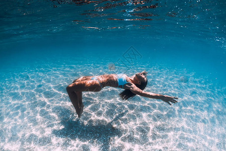 女子潜水员在沙海上滑翔在蓝图片