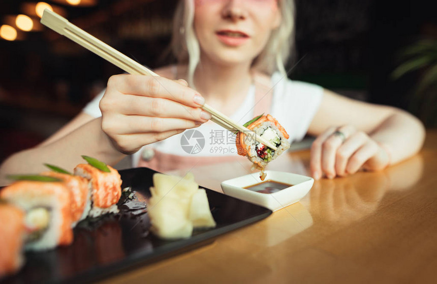 用筷子夹着寿司的特写照片图片
