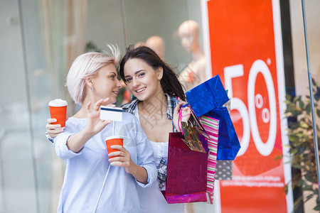成熟的母亲和她成年的女儿一起购物展示柜附近提着购物袋的妇女图片