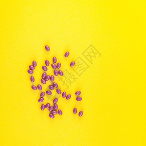 营养补充剂紫色药丸隔离在大胆的黄色背景与复制空间图片
