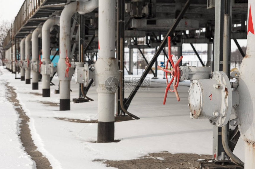 气体压缩机站用红色阀门输送气体的灰色金属管在冬季拍摄气压站冬季落雪输图片