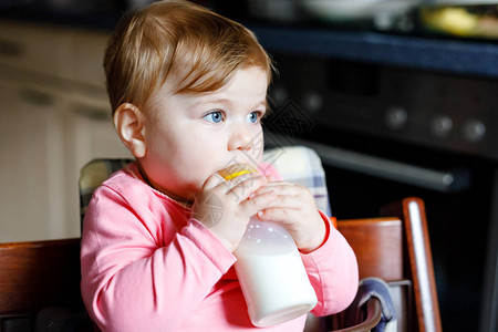 可爱的女婴拿着奶瓶喝配方奶婴儿的第一餐新出生的孩子图片