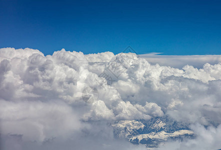 山峰覆盖着积雪蓝天和飞云的高山峰图片