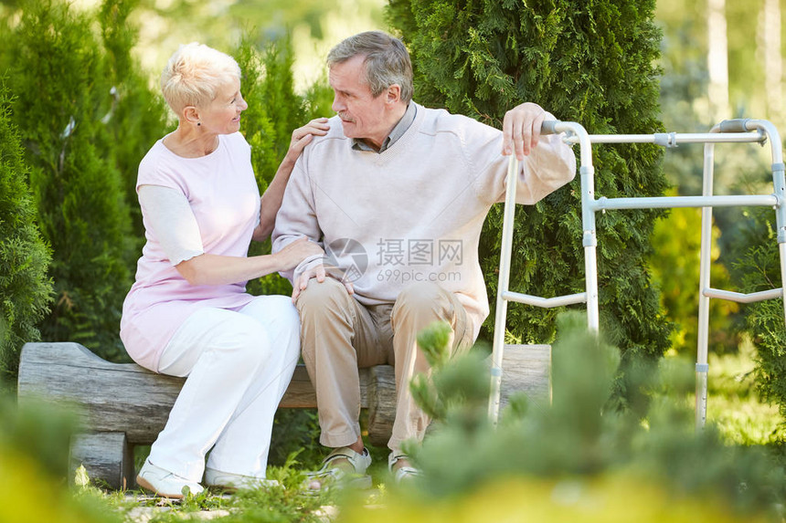 仰靠在公园中与护理士或妻子一起休息的行走者复制空间的老年图片