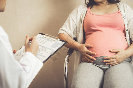 快乐的孕妇在医院或医疗诊所拜访妇科医生进行怀孕咨图片