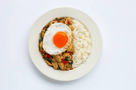 米饭配上炒鸡和圣罗勒煎鸡蛋白色背景图片
