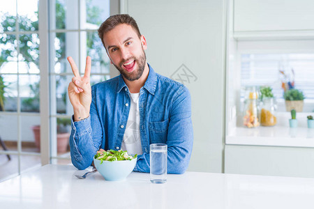 吃新鲜健康沙拉的帅哥笑着面朝镜头眨眼看图片