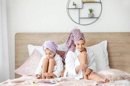 母亲和她的小女孩在浴袍里在图片