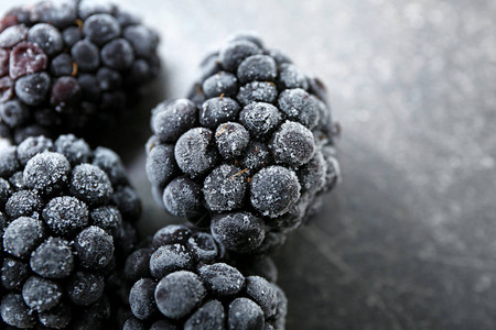 黑桌上美味的冷冻黑莓特写图片