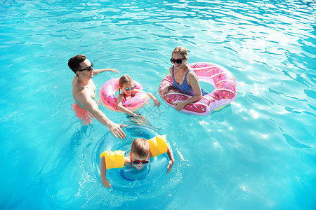 夏日快乐的家庭在游泳池里游泳图片
