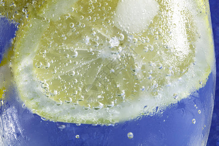 新鲜苏打水泡了冰块柠檬片和吸管在闪亮图片