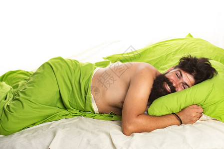 年轻人在家里用枕头睡在床上图片