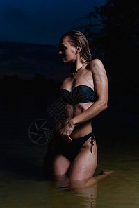 漂亮的模特儿在水里穿着黑色比基尼泳衣夜游图片