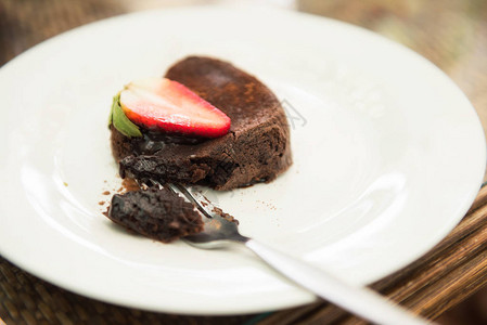 巧克力熔岩蛋糕和草莓放在木桌上的白板上图片