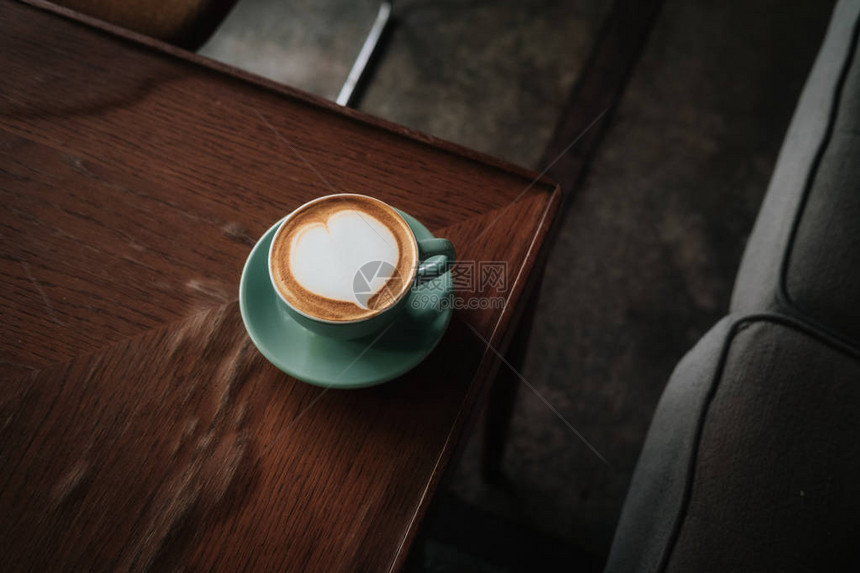 心在绿松石杯和木桌上的盘子里从上面暖色调滤镜效果咖啡店图片